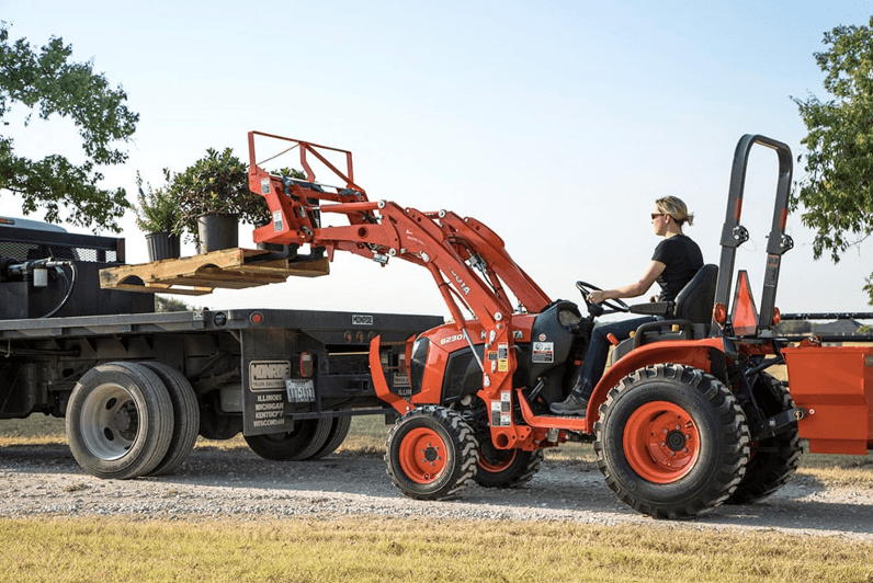 Woman loading pallet onto back of truck 