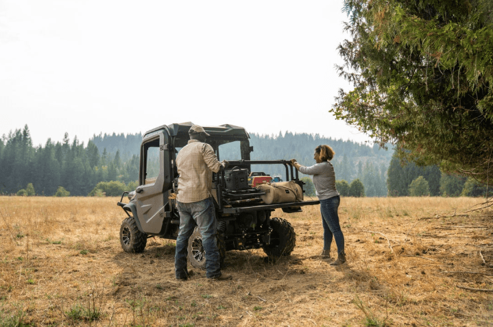 Couple unloading cargo bed of RTV