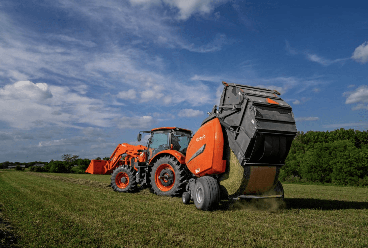 Baler attached to tractor maying a round bale
